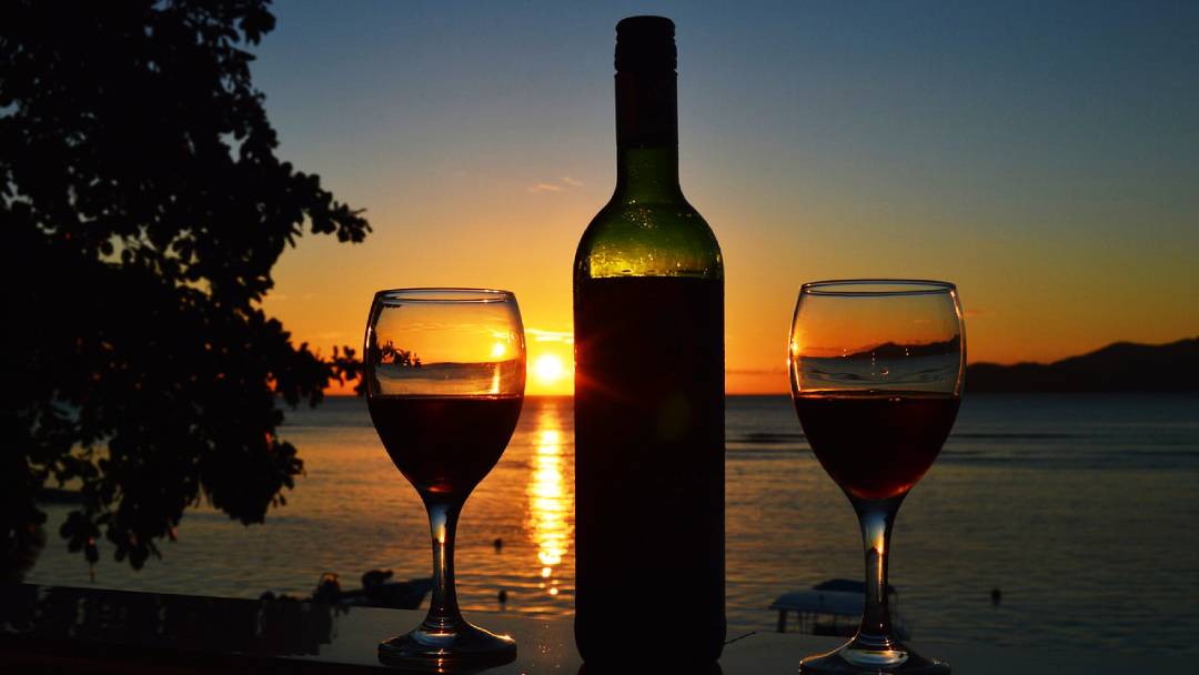 bottle of vine and sunset on Seychelles